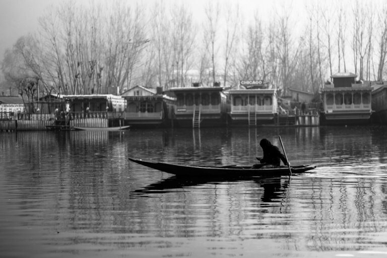 man riding on canoe on lake during daytime